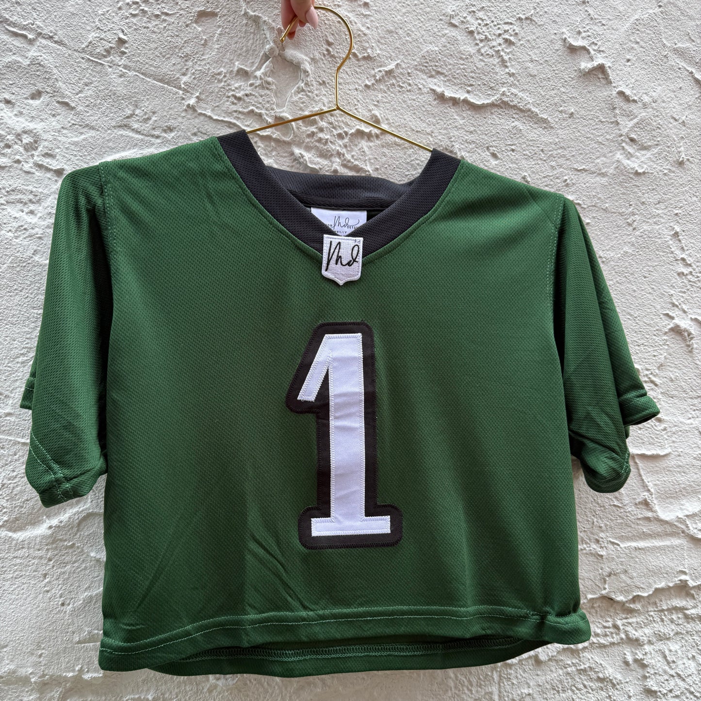 Green sports jersey with number 1 on a textured white background