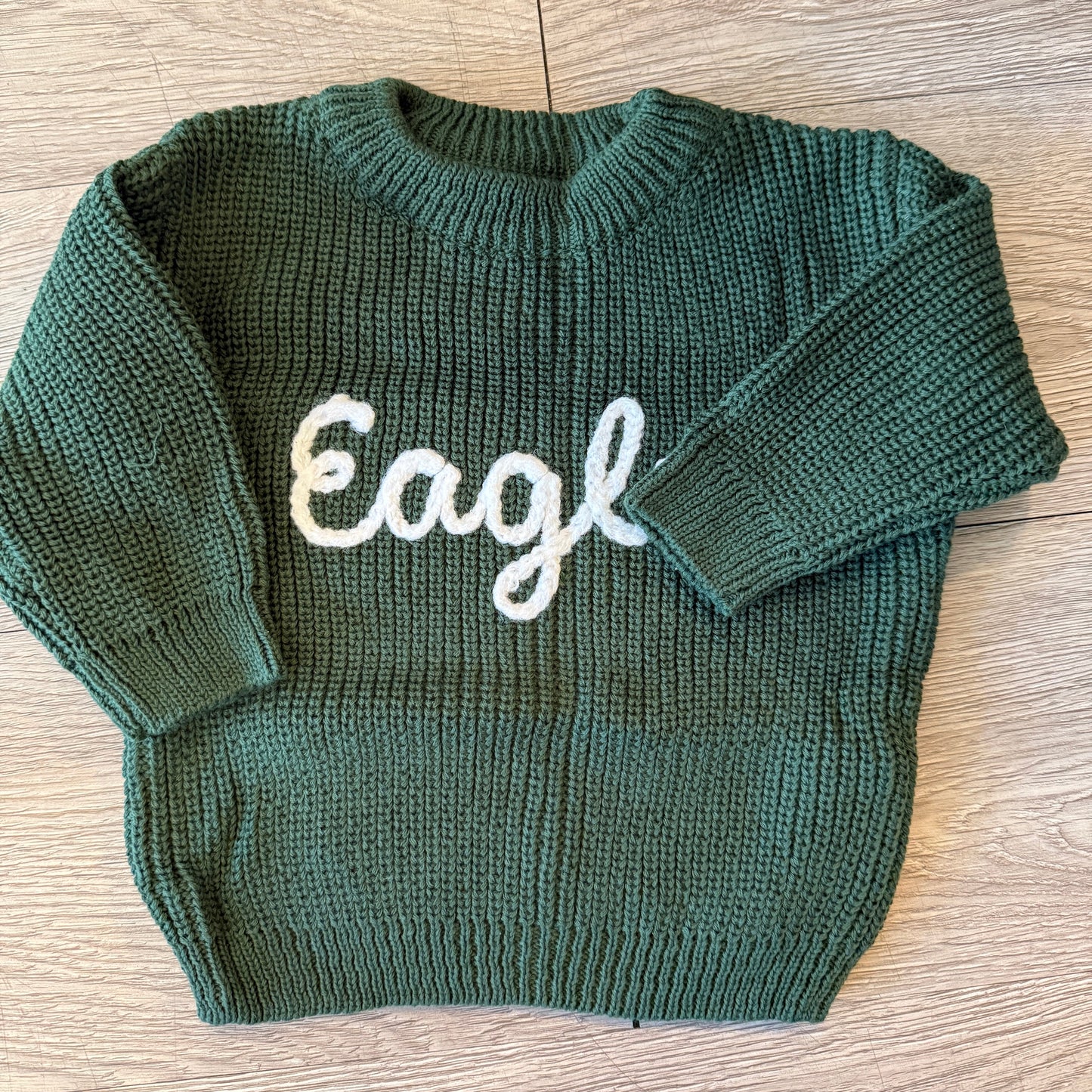 Philadelphia Eagles-inspired baby sweater with green and white details, perfect for tiny fans