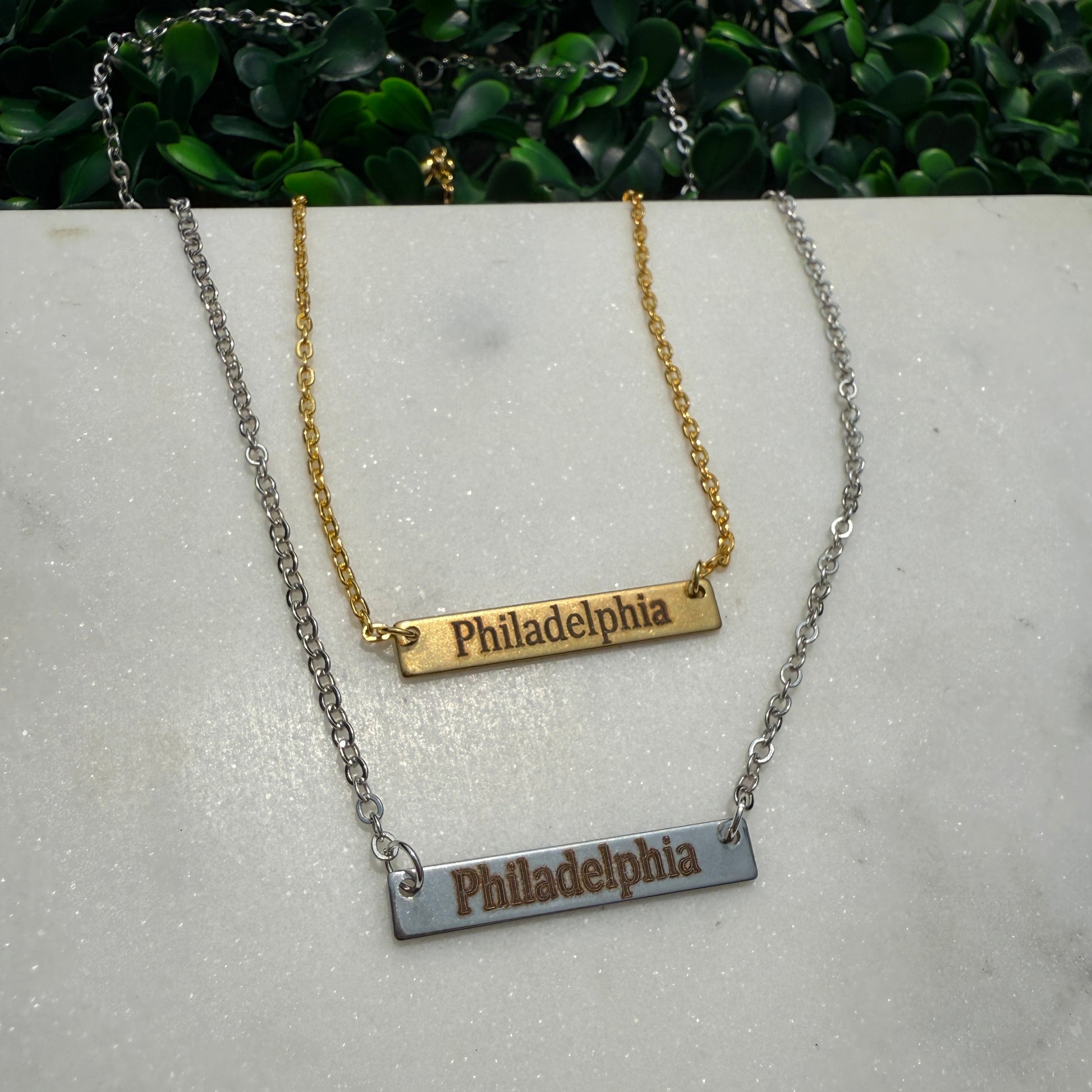 Necklace with 'Philadelphia' pendant on a gray surface