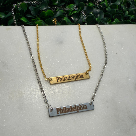 Necklace with 'Philadelphia' pendant on a gray surface