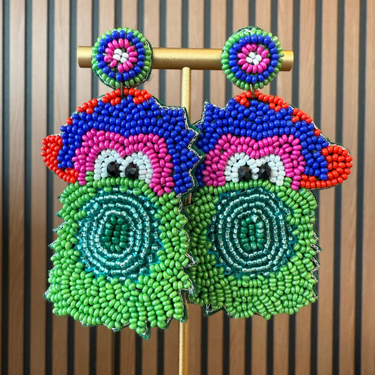 Colorful beaded phanatic earrings on a wooden stand with a striped background