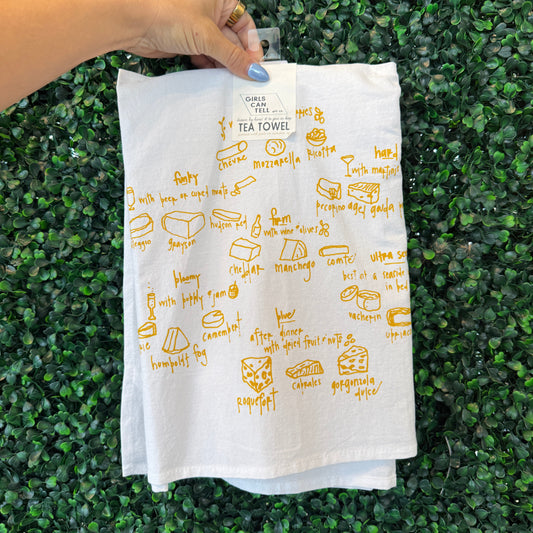 Hand holding a white cloth with yellow text and graphics on a green grass background