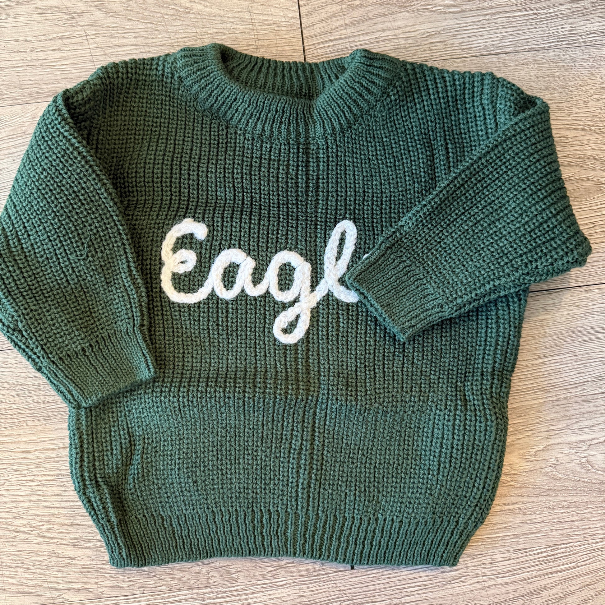 Philadelphia Eagles-inspired baby sweater with green and white details, perfect for tiny fans